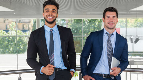 Zwei Männer in Anzügen gehen nebeneinander her