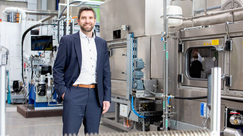 Prof. Dr. Matthias Weigold steht vor großen Gerätschaften zur wissenschaftlichen Forschung. 