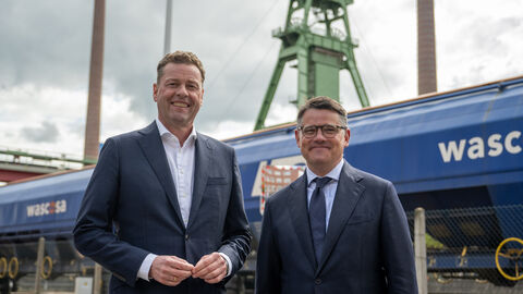 Ministerpräsident Rhein und der Vorstandsvorsitzende der K+S AG, Dr. Burkhard Lohr, stehen gemeinsam auf dem Firmengelände und lächeln in die Kamera.