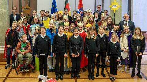 Viele Kinder stehen zusammen, teilweise als Könige verkleidet. 
