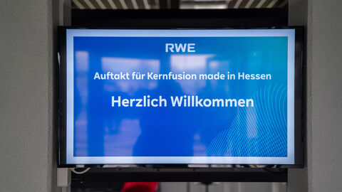 Blick auf einen Bildschirm mit der Aufschrift "Auftakt für Kernfusion made in Hessen - Herzlich Willkommen".