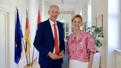 Kultusminister Armin Schwarz steht neben Bildungsministerin Karin Prien in einem Flur.