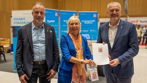 Digitalministerin Kristina Sinemus überreicht den Bescheid an Landrat Bernd Woide, links MdL Thomas Hering