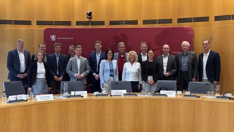 Mehrere Personen stehen vor einer roten Wand