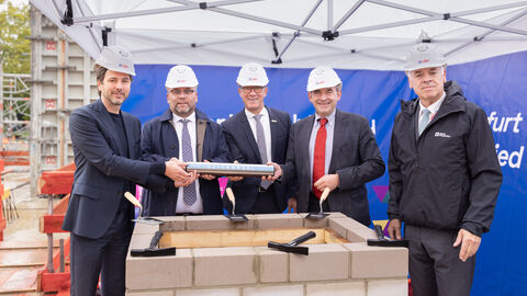 Prof. Dr. Marcus Gwechenberger (Dezernent für Planen und Wohnen der Stadt Frankfurt am Main), Timon Gremmels (Hessischer Minister für Wissenschaft und Forschung, Kunst und Kultur), Prof. Dr. Kai-Oliver Schocke (Präsident der Frankfurt UAS), Prof. Dr. R. Alexander Lorz (Hessischer Minister der Finanzen) und Thomas Platte (Direktor des Landesbetriebs Bau und Immobilien Hessen) legen den Grundstein für das Lehr- und Forschungsgebäude an der Frankfurt UAS.